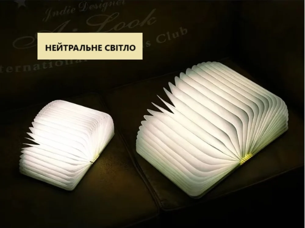 Дві лампи-книжки різного розміру з нейтральним світлом на дивані